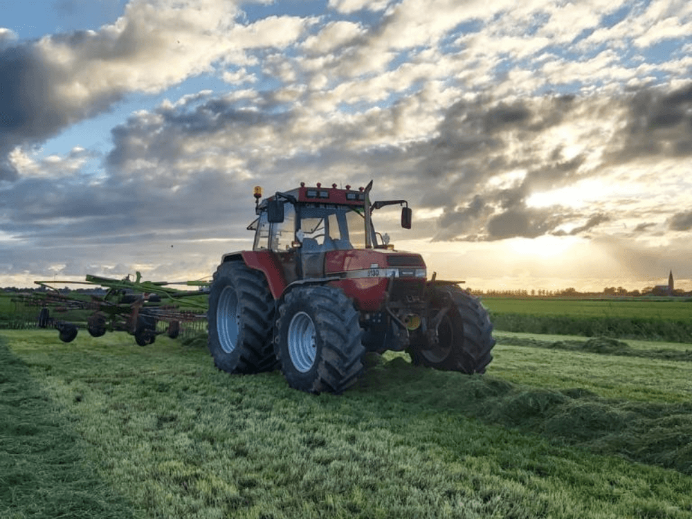 Tractor is gras aan het harken